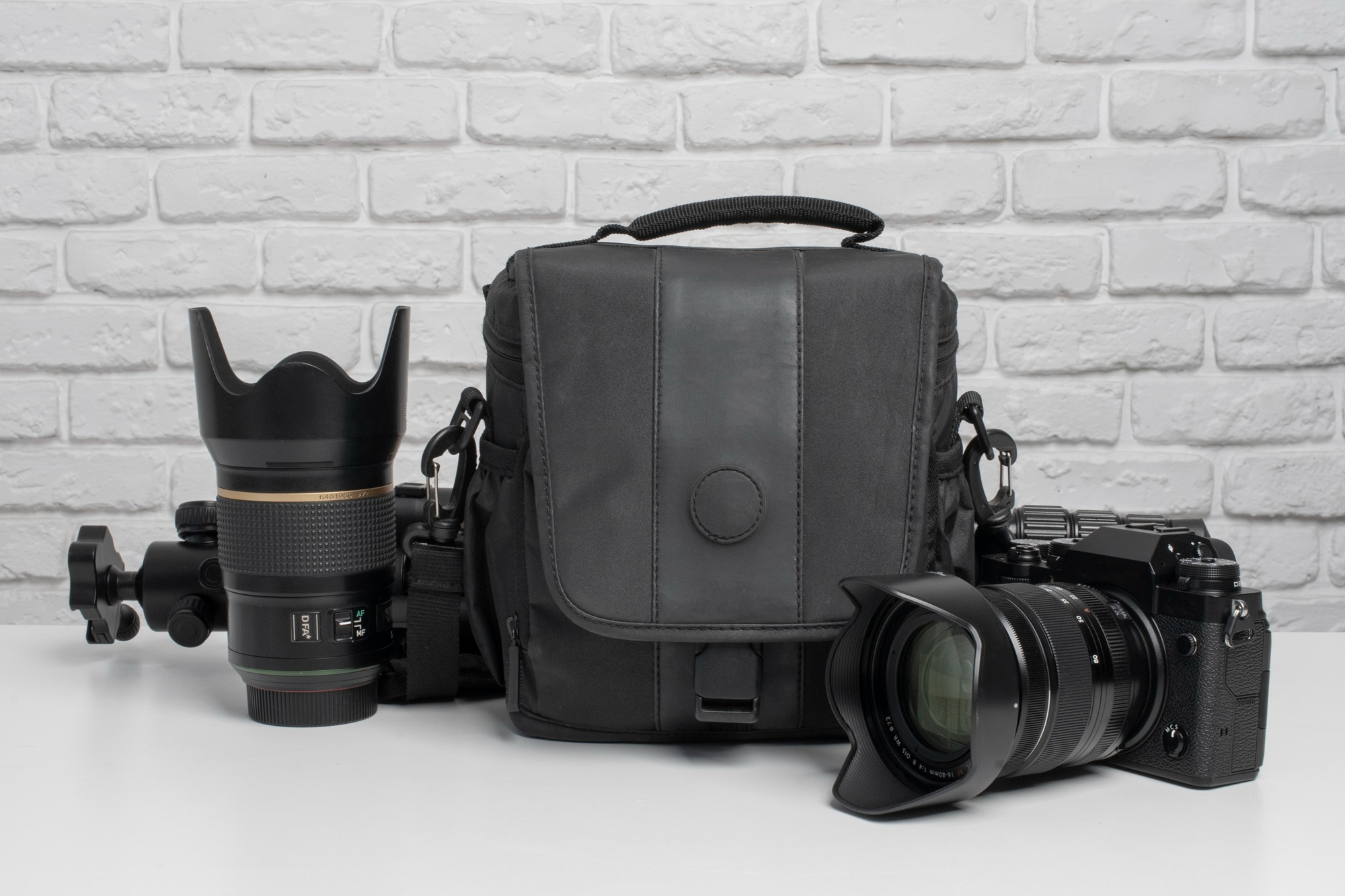 Professional camera, lens, and photography bag arranged on table