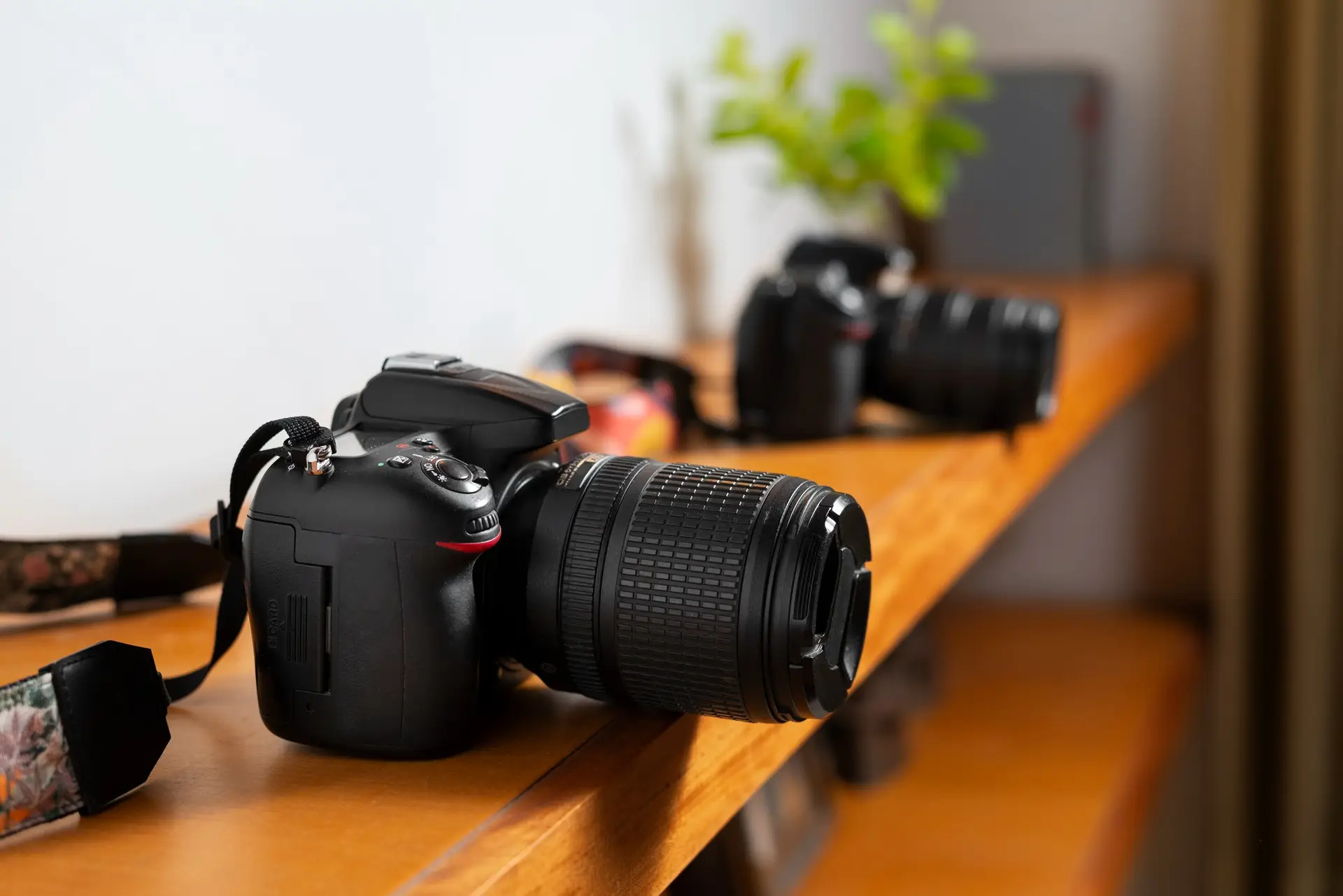 DSLR camera with zoom lens placed on wooden table in creative workspace