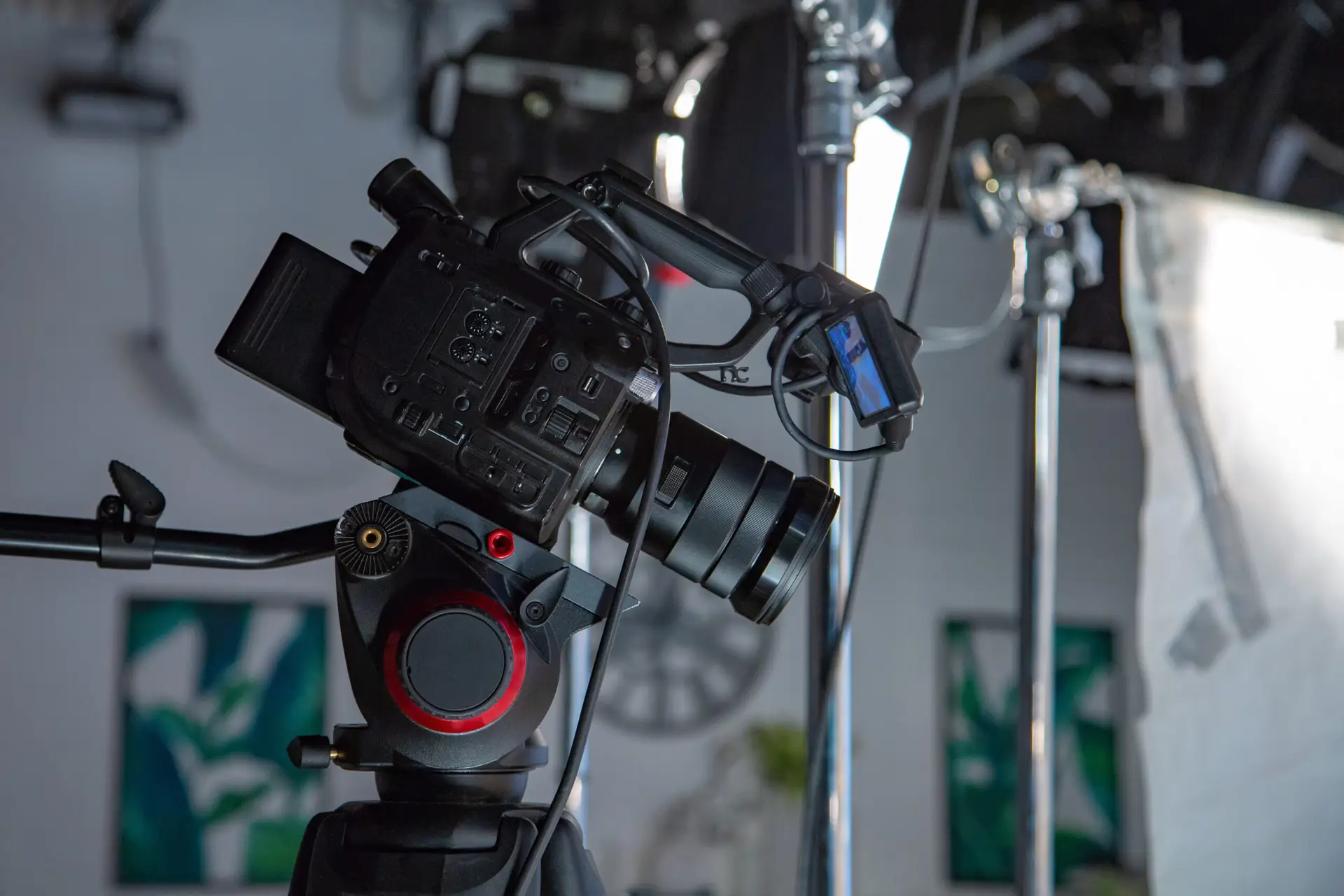 Professional video camera mounted on tripod inside a studio setup