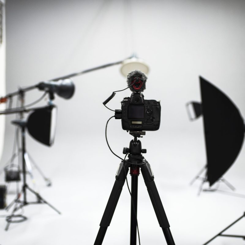Professional camera with microphone setup inside a modern photography and video production studio